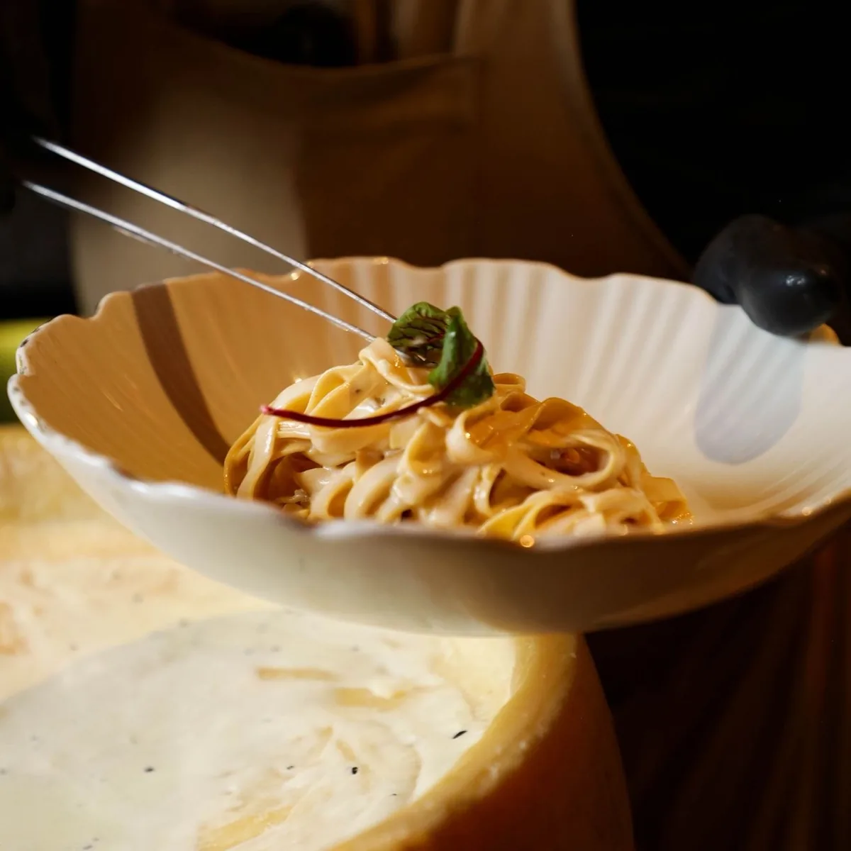 Fettuccine terminado dentro de una rueda de parmesano.