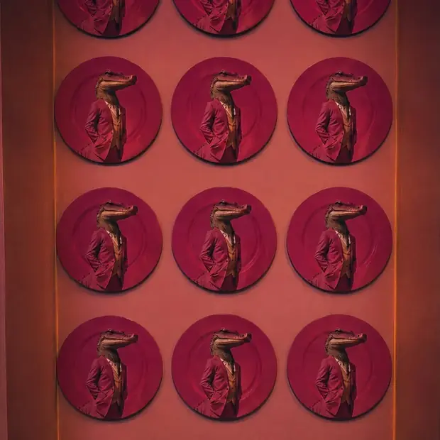 La pared de platos carmesí con el cocodrilo de la casa repetido.